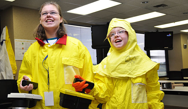 Two female students dressed in safety gear holding Geiger-Mueller counters